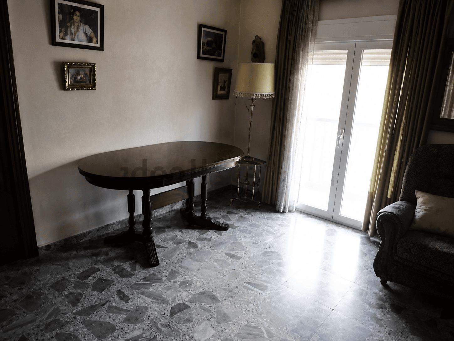 Salón comedor antes de la reforma, con suelo de terrazo y paredes oscuras