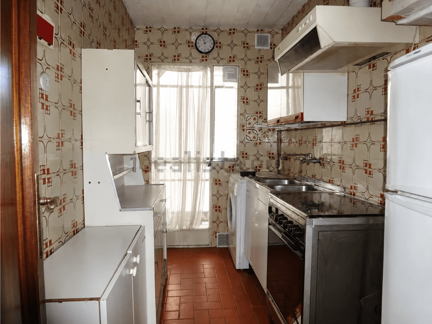 Cocina antes de la reforma, alicatada de pared a techo y con suelo de barro
